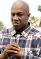 Deebo from Friday displaying an intimidating expression in a plaid shirt, embodying his tough character in the film.