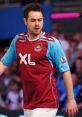 Danny Dyer wearing a West Ham United jersey, showcasing his support for the team during a vibrant football match.