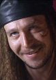 Drexl Spivey smirking in a leather hat from True Romance, showcasing his iconic and quirky character in the film.