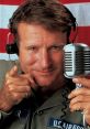 Adrian from "Good Morning Vietnam," playfully pointing while holding a microphone, capturing a moment of radio entertainment.