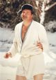 Cousin Eddie in a white robe and fur hat, enjoying a drink in the snowy landscape from the movie "Vacation.