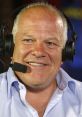 Andy Gray, renowned football commentator, smiling while wearing headphones and a microphone, sharing sports insights.