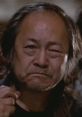 Egg Shen, the wise sorcerer from Big Trouble in Little China, displaying determination and strength in a pivotal scene.