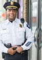 Police officer in uniform with badge, smiling confidently outside, representing community safety and law enforcement.