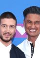 Vinny Guadagnino and DJ Pauly D smile together at a red carpet event, showcasing their vibrant personalities and style.