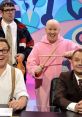 Four comedians posing playfully; one in a pink outfit with drumsticks, capturing a fun moment from "Shooting Stars.