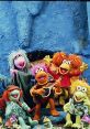 Colorful Fraggles from Fraggle Rock joyfully posing together against a vibrant blue backdrop, celebrating friendship and music.