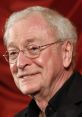 Michael Caine smiling, wearing glasses and a black shirt, with a red background, showcasing his charming personality.