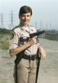 Deputy Trudy Wiegel from Reno 911! poses confidently holding a gun, showcasing her character's strength and humor.