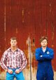 Two main characters from Letterkenny stand confidently against a rustic, red barn, showcasing their distinctive styles.