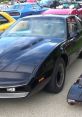 Classic black KITT from Knight Rider, showcasing sleek design at a vibrant car show with various vintage vehicles.