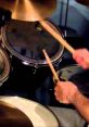 Close-up of a drummer's hands holding sticks, striking the snare and cymbals, creating an energetic drum roll.