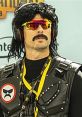 Dr. Disrespect cosplay featuring iconic hairstyle, sunglasses, and tactical vest at a gaming event.