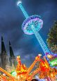 Thrilling ride at Tilburgse Kermis, illuminated by vibrant lights against a dramatic evening sky.