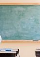 Clean teacher's board in a classroom setting with empty desks and a globe, ready for educational activities.