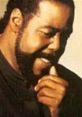 Barry White smiling thoughtfully, showcasing his signature style and charisma, a legend in soul and R&B music.