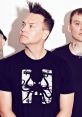 Mark Hoppus from Blink-182 poses in a graphic tee, showcasing his unique style and iconic punk rock vibe.