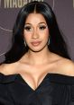 Cardi B stunning in a black off-shoulder dress, showcasing her signature glam and radiant beauty at a red carpet event.