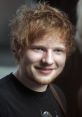 Ed Sheeran smiling, showcasing his signature tousled hair and casual style, exuding a relaxed, approachable vibe.