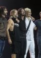 Foo Fighters band members pose together on stage, showcasing camaraderie and excitement during a live performance.