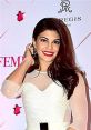 Jacqueline Fernandez smiling at a glamorous event, showcasing her elegant style and vibrant red lipstick.