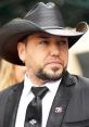 Jason Aldean in a stylish black suit with a cowboy hat, showcasing his signature country music star look at an event.