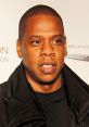 Jay-Z attending a high-profile event, showcasing his signature style in a black jacket and t-shirt, exuding confidence.