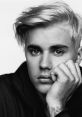 Justin Bieber gazes thoughtfully, showcasing his signature style with platinum hair and a contemplative expression.