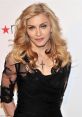 Madonna, elegantly dressed in black lace, showcases her signature style with long, blonde hair and striking accessories.