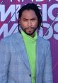 Miguel showcases bold fashion in a plaid suit and vibrant green turtleneck at the Radio Music Awards red carpet.