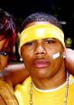 Nelly in a yellow outfit with a headband, showcasing his unique style and charisma, possibly with Kelly Rowland.