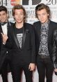 One Direction members at the BRIT Awards 2014, showcasing their trendy styles and charismatic presence on the red carpet.