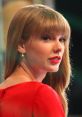 Taylor Swift showcases her glamorous look, featuring striking red lips and elegant style at a public event.