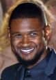 Usher flashes a bright smile, showcasing his signature style and charisma at a glamorous event.