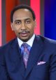 Stephen A. Smith in a blue suit with a vibrant pink tie and pocket square, known for his insightful sports commentary.