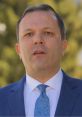 Oliver Spasovski giving a speech outdoors, dressed in a blue suit and patterned tie, emphasizing leadership and communication.