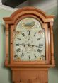 Grandfather clock from London, 1845, featuring a classic bell type design and intricate floral detailing on the face.