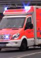 German emergency services ambulance with flashing lights responding to an emergency call on city streets.