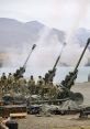 Military personnel operate artillery while smoke rises during a training exercise, showcasing gunfire and coordination.