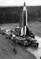 Launch site of a World War II German V2 Rocket, featuring support vehicles and technicians preparing for launch.