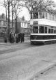 Sheffield Tram No. 189 approaches a stop, with passengers waiting on a tree-lined street. Classic transport scene captured.