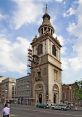 St. Mary-Le-Bow Church in London, featuring its iconic tower and clock, under renovation with scaffolding visible.