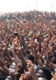 Crowd of passionate Nigerians raising hands at an event, showcasing enthusiasm and unity in a vibrant gathering.