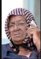 Confused elderly woman in a headscarf, holding a phone, expressing perplexity and curiosity.