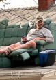 Man lounging on a rooftop in a recliner, enjoying a drink, embodying the relaxed spirit of a Redneck Roofer lifestyle.