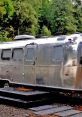 Sleek Airstream trailer surrounded by lush greenery, perfect for an On-Air Stream setup in nature's tranquility.