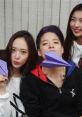 Members of Small Group FX playfully holding purple paper airplanes, showcasing their fun and vibrant personality together.