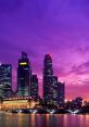 Stunning city skyline at dusk, with illuminated skyscrapers against a vibrant purple sky reflecting on the water.