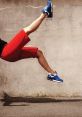 Person in red shorts and blue sneakers comically falling on a gritty background, capturing a moment of unexpected fail.