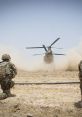 Military soldiers watching a helicopter take off, creating a dust cloud in a desert environment during a tactical operation.